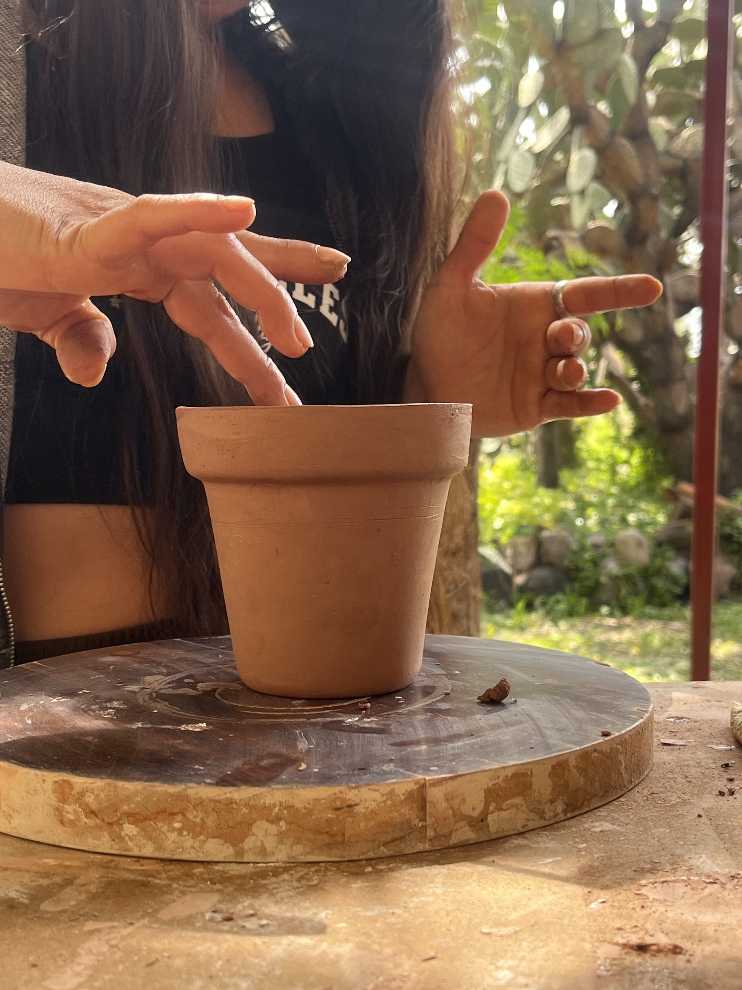 Hands shaping a clay pot during a ceramics experience